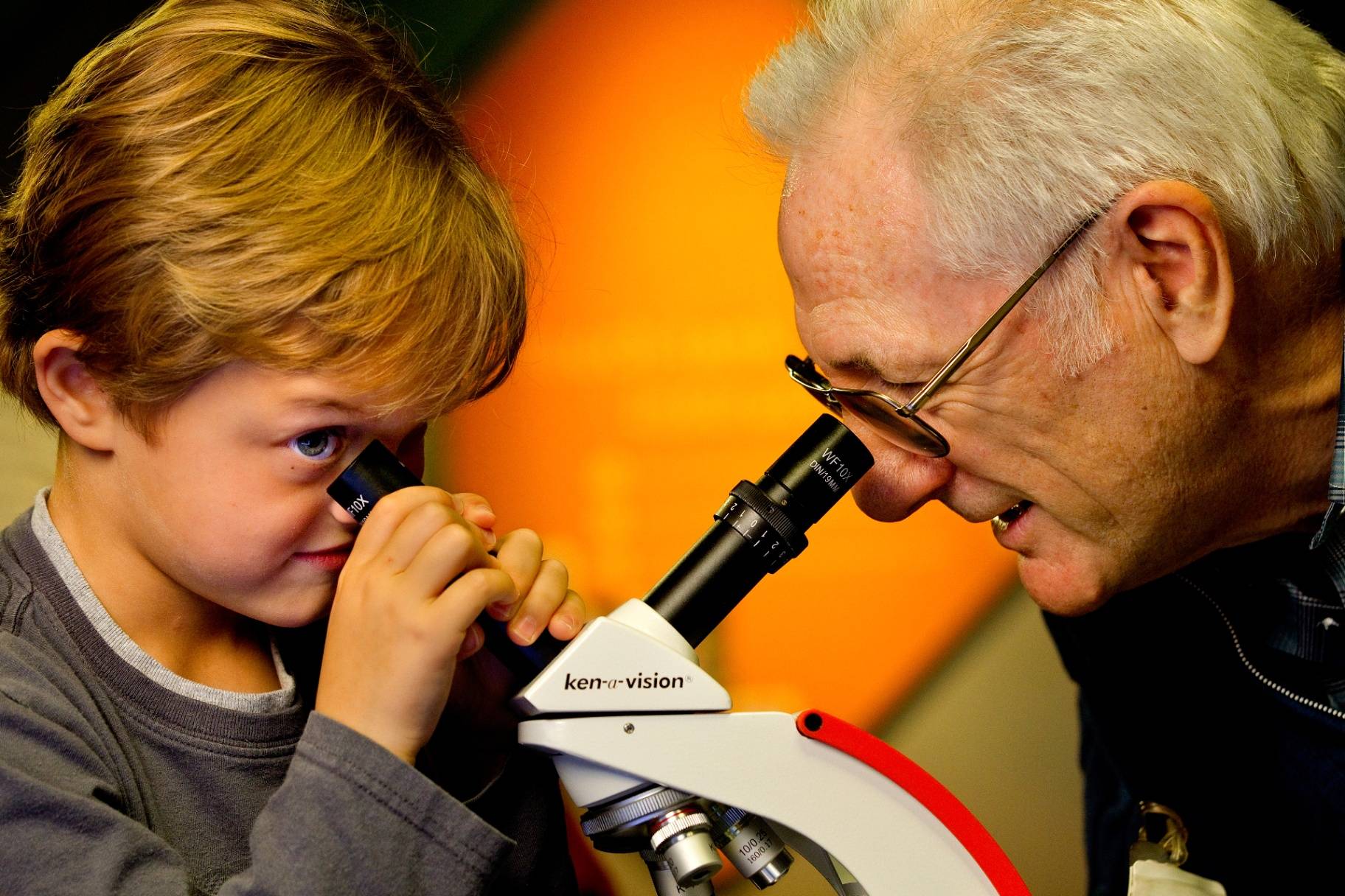 Grandfather and grandson looking through a microscope