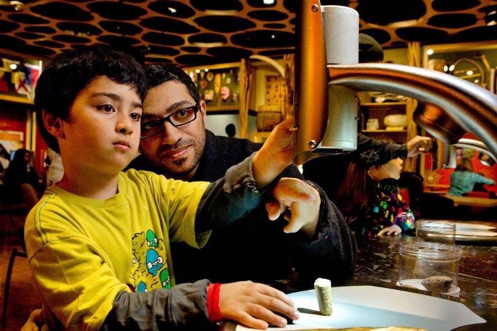 Father and son using microscope