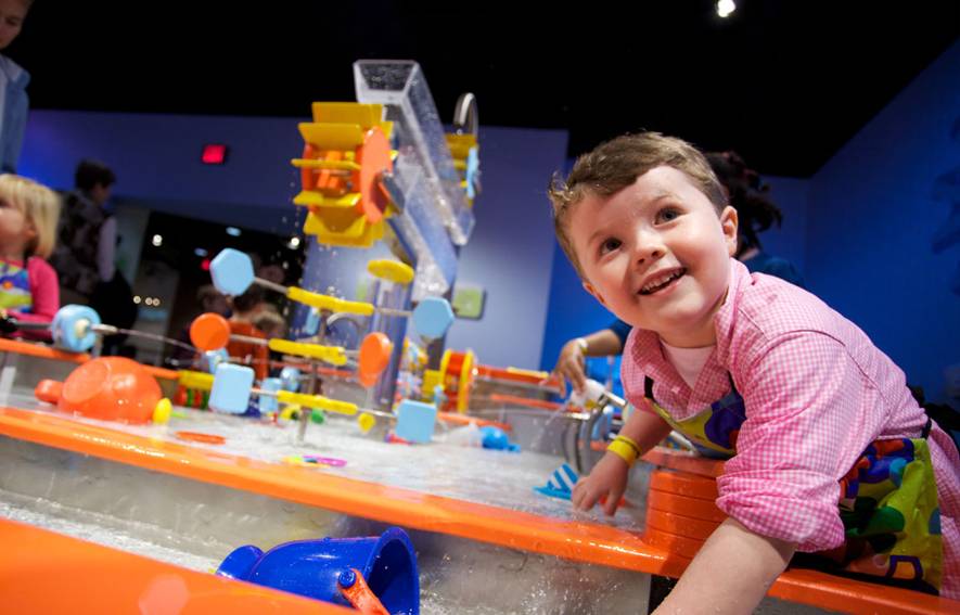 Boy smiling at water table
