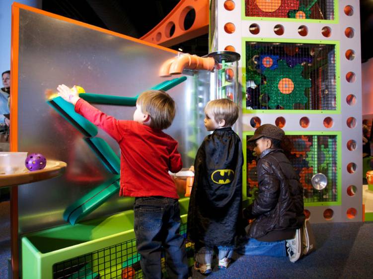 Kids exploring ball ramp exhibit
